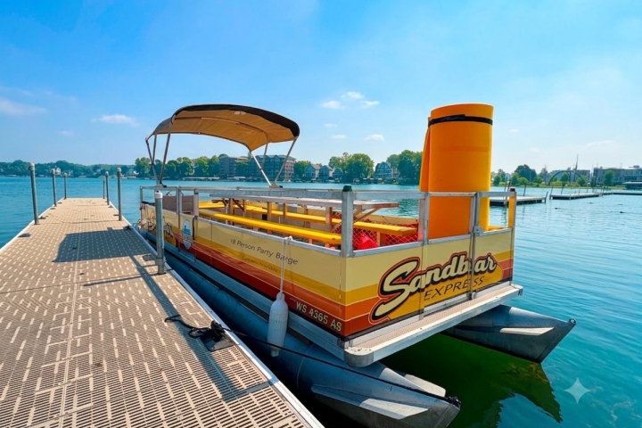 Colorful pontoon boat docked on a sunny day by the lake.